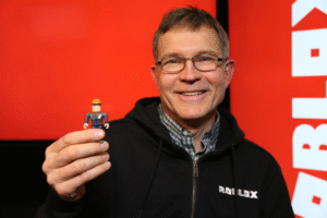 Imagem de destaque mostrando os fundadores do Roblox, David Baszucki e Erik Cassel, ao lado do logo da plataforma.